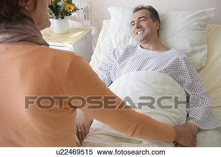 Visitor Comforting Patient in Hospital View Large Photo Image Stock Photography - Visitor Comforting Patient in Hospital. Fotosearch