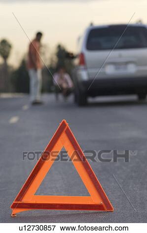 Stock Photo - Warning triangle in front of broken down car. Fotosearch