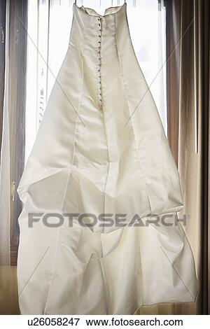 Wedding dress hanging indoors View Large Photo Image Stock Photo - Wedding dress hanging indoors. Fotosearch