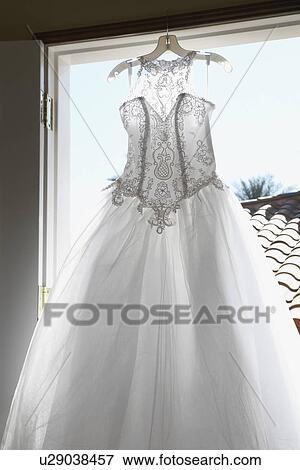 Stock Photo - Wedding dress hanging indoors. Fotosearch