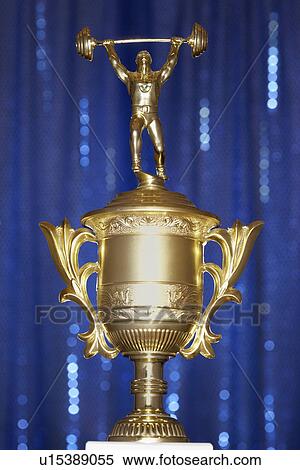 Stock Photography - Weightlifting Trophy in front of blue curtain. Fotosearch