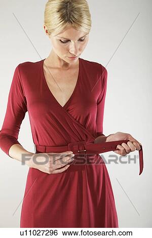 Stock Photograph - Woman Adjusting Belt. Fotosearch