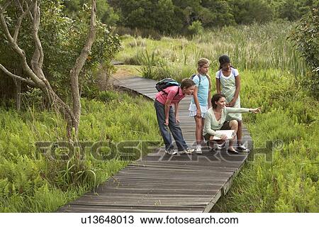 Stock Image - Woman and Children Spectating Plants. Fotosearch