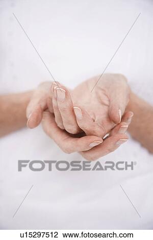 Stock Image - Woman Cupping Her Hands, mid section. Fotosearch