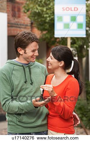 Woman giving new house key to partner View Large Photo Image Stock Photograph - Woman giving new house key to partner. Fotosearch