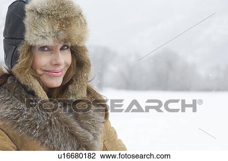 Woman in fur coat and hat in snow covered field, portrait. View Large Photo Image Stock Image - Woman in fur coat and hat in snow covered field, portrait.. Fotosearch