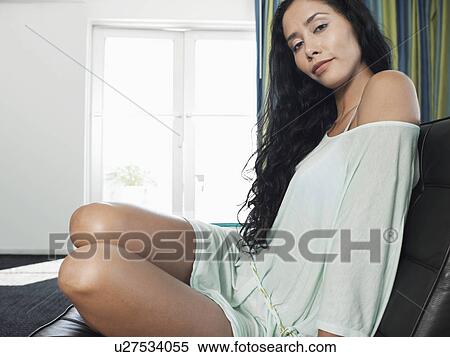 Stock Photography - Woman in nightwear on sofa. Fotosearch