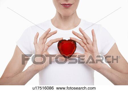 Woman in white t-shirt holding red glass heart in both hands View Large Photo Image Stock Photograph - Woman in white t-shirt holding red glass heart in both hands. Fotosearch