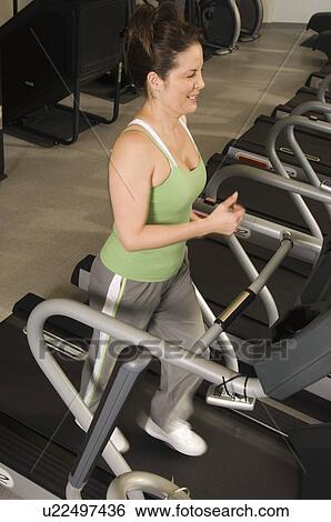 Woman Jogging on Treadmill at Health Club View Large Photo Image Stock Photograph - Woman Jogging on Treadmill at Health Club. Fotosearch