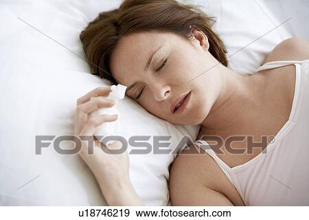 Stock Photo - Woman lying in bed with cold, close up. Fotosearch
