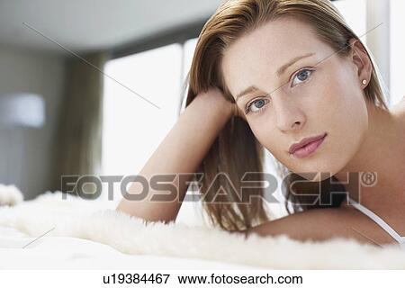 Woman relaxing on bed, portrait, close-up View Large Photo Image Stock Photo - Woman relaxing on bed, portrait, close-up. Fotosearch