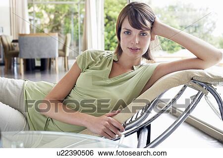Stock Photograph - Woman relaxing on chaise long, portrait. Fotosearch