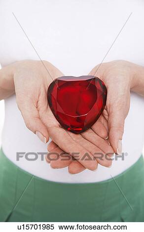 Woman showing heart-shaped jewel, mid section View Large Photo Image Stock Photography - Woman showing heart-shaped jewel, mid section. Fotosearch