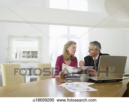 Woman sitting at table with financial advisor View Large Photo Image Stock Image - Woman sitting at table with financial advisor. Fotosearch