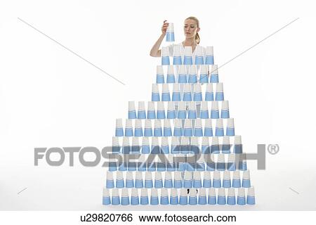Woman stacking plastic cups into pyramid against white background View Large Photo Image Stock Photograph - Woman stacking plastic cups into pyramid against white background. Fotosearch