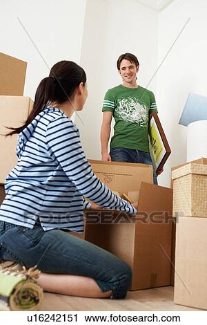 Woman unpacking box, man looking View Large Photo Image Stock Image - Woman unpacking box, man looking. Fotosearch