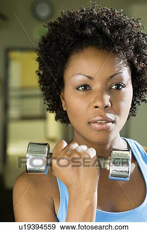 Woman using dumbbell indoors, (close-up), (portrait) View Large Photo Image Stock Photo - Woman using dumbbell indoors, (close-up), (portrait). Fotosearch