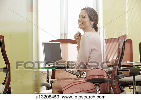 Woman using laptop in conference room View Large Photo Image Stock Photo - Woman using laptop in conference room. Fotosearch