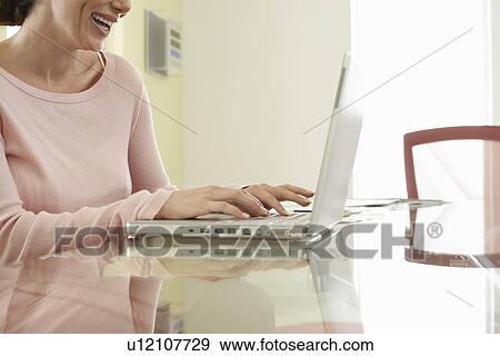Stock Photo - Woman using laptop in office. Fotosearch