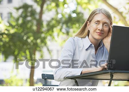 Woman using laptop outdoors View Large Photo Image Stock Photo - Woman using laptop outdoors. Fotosearch
