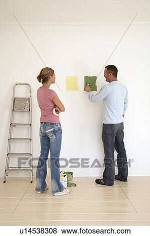 Woman watching man testing paint colours on wall View Large Photo Image Stock Photo - Woman watching man testing paint colours on wall. Fotosearch