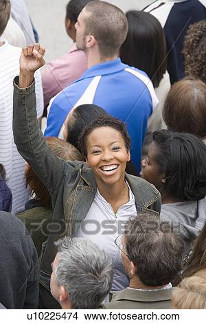 Picture - Woman with arm raised in crowd. Fotosearch