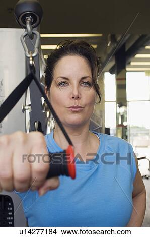 Woman Working Out on Weightlifting Machine View Large Photo Image Picture - Woman Working Out on Weightlifting Machine. Fotosearch