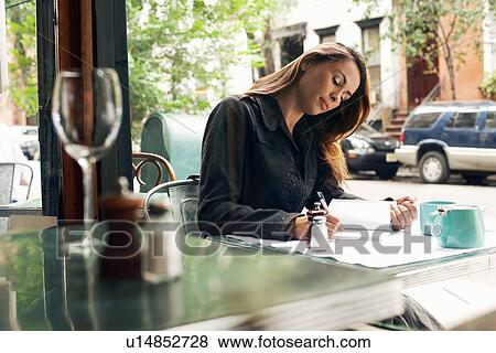 Woman writing at sidewalk cafe View Large Photo Image Stock Photo - Woman writing at sidewalk cafe. Fotosearch