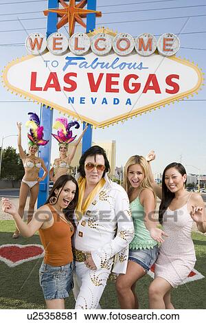 Women and Elvis impersonator posing in front of Las Vegas welcome sign, Nevada, USA View Large Photo Image Stock Image - Women and Elvis impersonator posing in front of Las Vegas welcome sign, Nevada, USA. Fotosearch