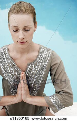 Stock Photography - Women in yoga position by swimming pool, elevated view. Fotosearch