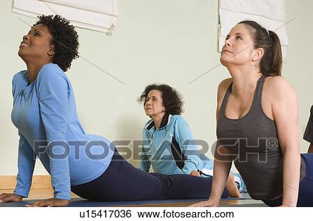Stock Photograph - Women Stretching Backs in Yoga Class. Fotosearch