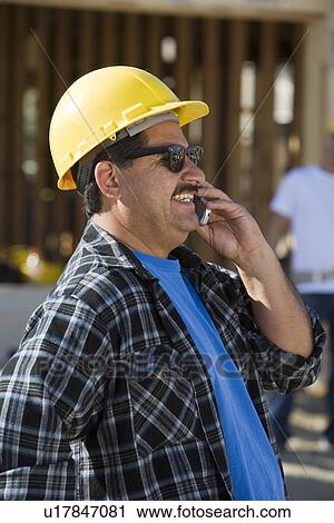 Worker using mobile phone in construction site View Large Photo Image Stock Image - Worker using mobile phone in construction site. Fotosearch