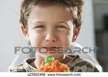 Young boy eating cupcake, head and shoulders View Large Photo Image Stock Photo - Young boy eating cupcake, head and shoulders. Fotosearch