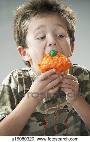 Young boy eating cupcake View Large Photo Image Stock Image - Young boy eating cupcake. Fotosearch