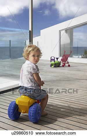 Young Boy riding toy tricycle on wooden porch, back view View Large Photo Image Stock Image - Young Boy riding toy tricycle on wooden porch, back view. Fotosearch