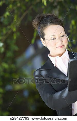 Stock Image - Young business woman with diary, outdoors. Fotosearch