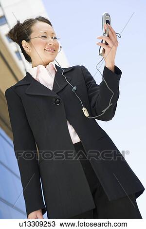 Young businesswoman using mobile outdoors, portrait View Large Photo Image Stock Image - Young businesswoman using mobile outdoors, portrait. Fotosearch