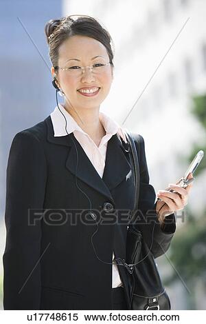 Young businesswoman using mobile outdoors, portrait View Large Photo Image Stock Photography - Young businesswoman using mobile outdoors, portrait. Fotosearch
