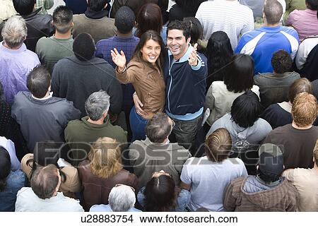 Picture - Young couple embracing among crowd. Fotosearch