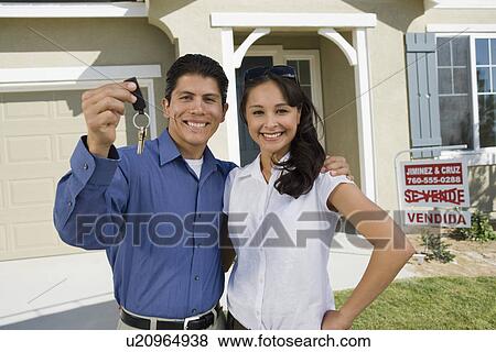 Young couple holding keys outside new home, portrait View Large Photo Image Stock Photo - Young couple holding keys outside new home, portrait. Fotosearch