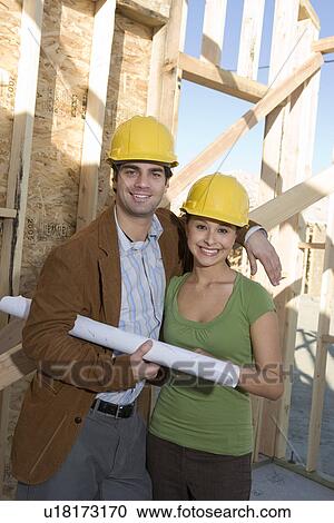 Stock Image - Young couple in construction site. Fotosearch