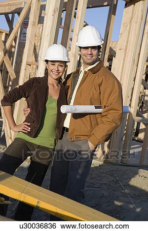 Stock Photograph - Young couple in construction site. Fotosearch