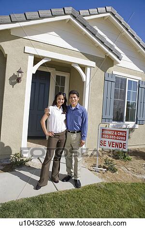 Stock Photograph - Young couple in front of new house. Fotosearch