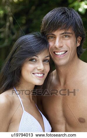 Stock Image - Young couple in swimwear in forest, portrait. Fotosearch