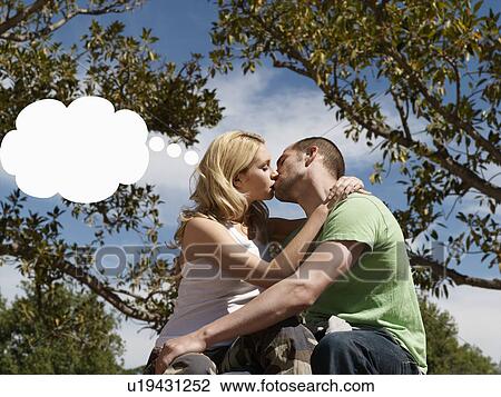 Young couple kissing with think bubble above woman's head View Large Photo Image Stock Image - Young couple kissing with think bubble above woman's head. Fotosearch