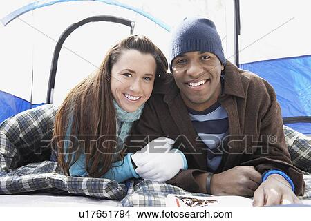 Young couple lying in sleeping bags in tent, portrait. View Large Photo Image Picture - Young couple lying in sleeping bags in tent, portrait.. Fotosearch