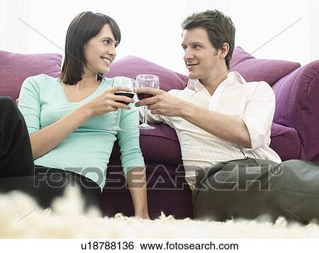 Young couple relaxing on sofa, toasting with wine View Large Photo Image Stock Photograph - Young couple relaxing on sofa, toasting with wine. Fotosearch
