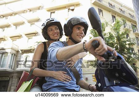 Stock Photo - Young Couple Riding Motorscooter. Fotosearch