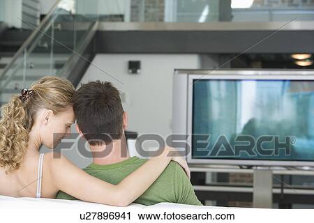 Young couple sitting on sofa View Large Photo Image Stock Image - Young couple sitting on sofa. Fotosearch