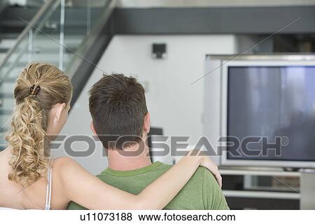 Young couple sitting on sofa View Large Photo Image Stock Photo - Young couple sitting on sofa. Fotosearch